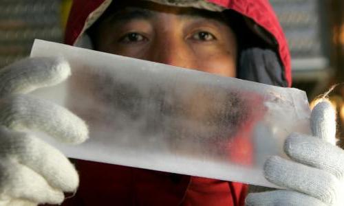 A scientist holds out a cylinder of ice.